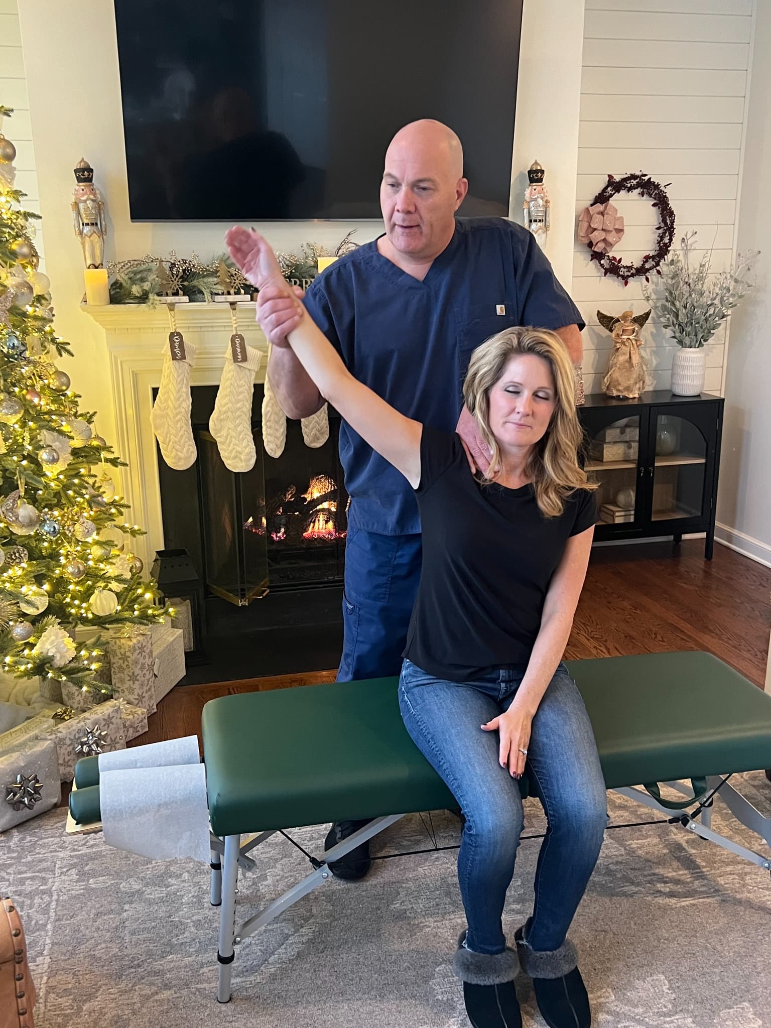 Dr. David DeFries assisting a patient with shoulder movement during a home visit